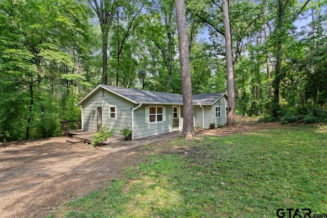 ranch-style house with a wooden deck and a front yard