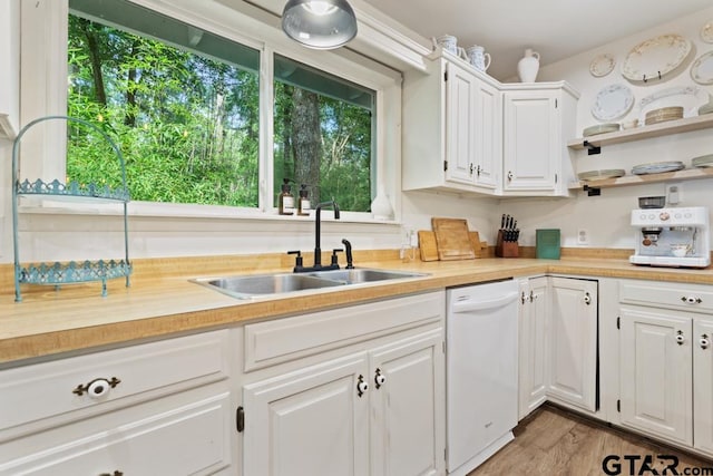 kitchen featuring dishwasher, sink, light hardwood / wood-style floors, and white cabinets