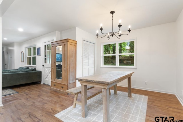 dining space featuring hardwood / wood-style flooring and a chandelier