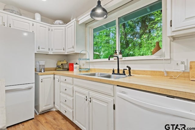 kitchen with white cabinetry, white appliances, sink, and light hardwood / wood-style floors