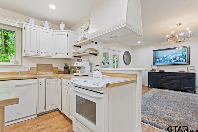 kitchen with white cabinets, kitchen peninsula, light hardwood / wood-style floors, and white appliances