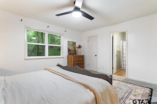 bedroom with carpet floors, ceiling fan, and ensuite bath