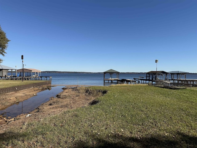 view of dock with a yard, a water view, and a gazebo