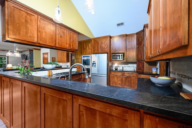 17889 County Road 134, Flint, TX 75762 - kitchen with appliances with stainless steel finishes, tasteful backsplash, high vaulted ceiling, brown cabinetry, and a peninsula