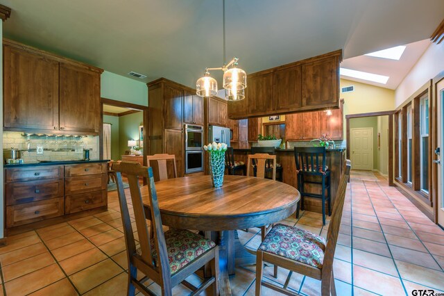 17889 County Road 134, Flint, TX 75762 - dining space featuring light tile patterned floors, a skylight, lofted ceiling, and a chandelier