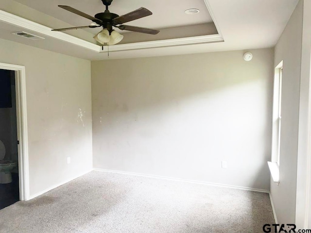 spare room with ceiling fan, carpet floors, and a raised ceiling