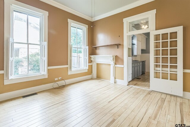 293 S Barron, Rusk, TX 75785 - unfurnished living room with light wood finished floors and ornamental molding