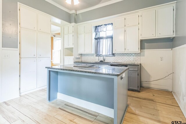 293 S Barron, Rusk, TX 75785 - kitchen featuring a center island, crown molding, stone countertops, light wood-style flooring, and white cabinetry