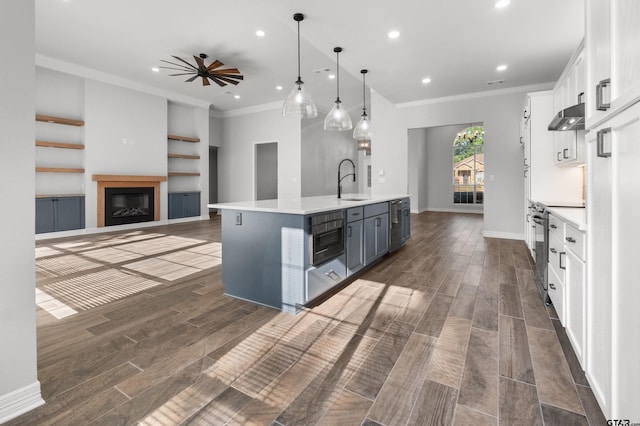 kitchen featuring crown molding, stainless steel range with electric stovetop, light countertops, white cabinets, and under cabinet range hood