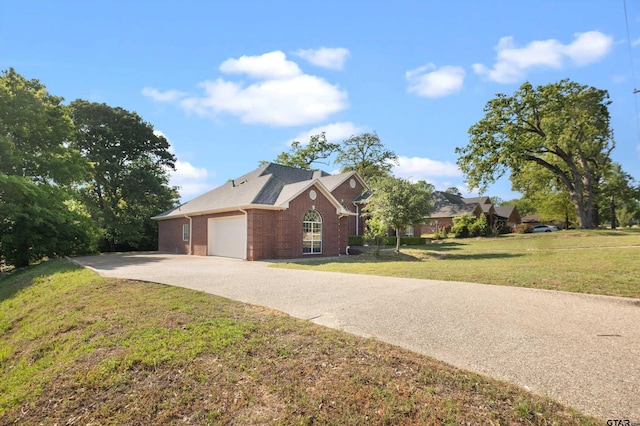 exterior space featuring a lawn, driveway, brick siding, and a garage