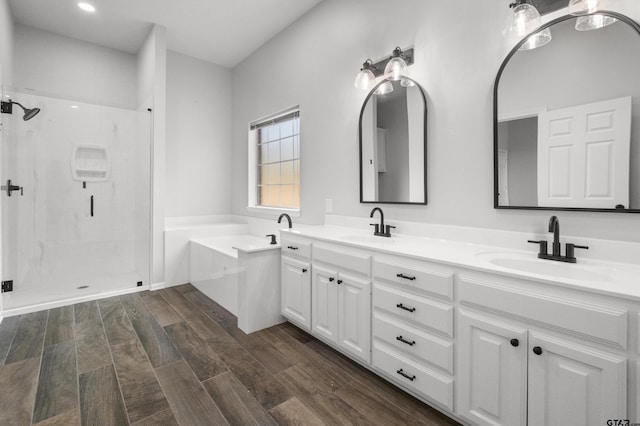 full bathroom featuring a bath, a sink, a shower stall, and double vanity