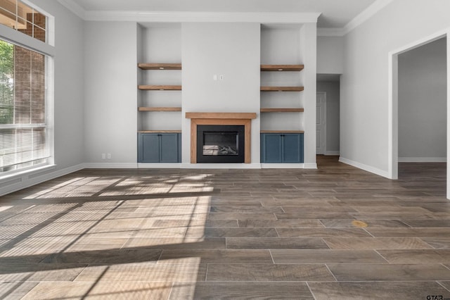 unfurnished living room featuring a wealth of natural light, ornamental molding, built in features, and baseboards