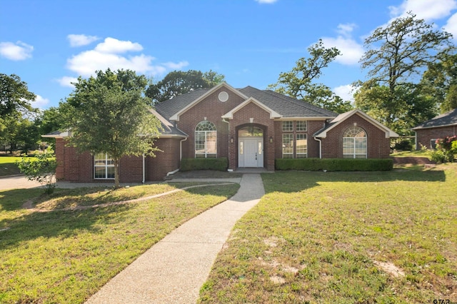 view of front of home with brick siding and a front yard