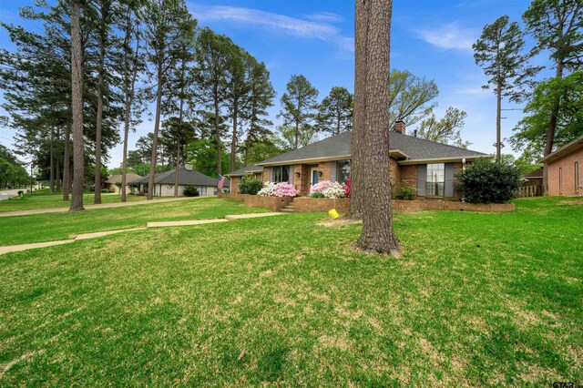 1261 Luann Ln, Tyler, TX 75703 - back of house featuring a yard, brick siding, a fenced backyard, and a patio