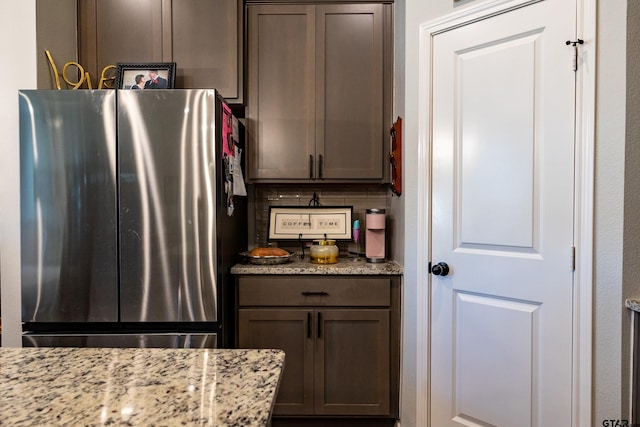 1420 Allison Ln, Lindale, TX 75771 - kitchen with freestanding refrigerator, light stone counters, and dark brown cabinetry