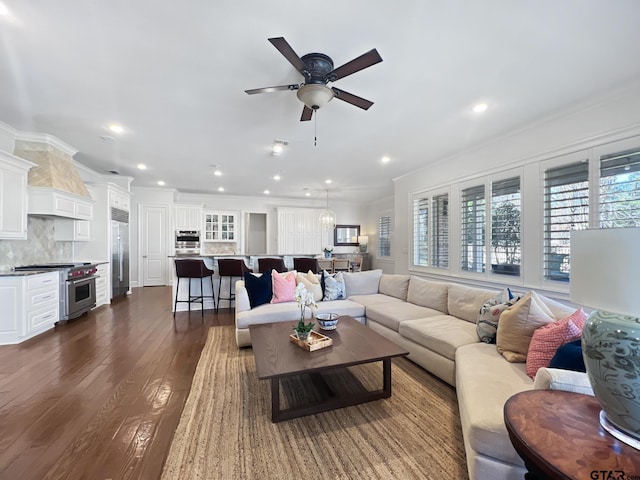 living room with crown molding, dark hardwood / wood-style floors, and ceiling fan