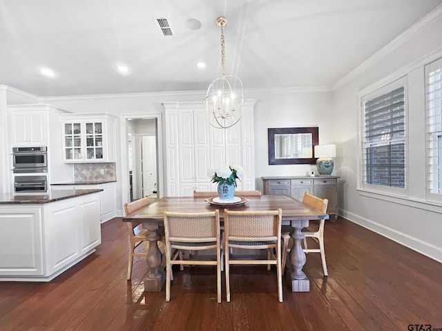 dining room with crown molding, dark wood-type flooring, and a chandelier