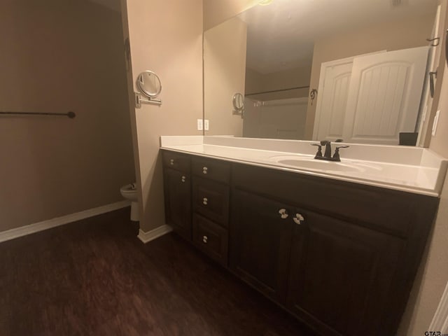 5848 Grace Ave, Tyler, TX 75707 - full bath with wood finished floors, toilet, vanity, baseboards, and a shower