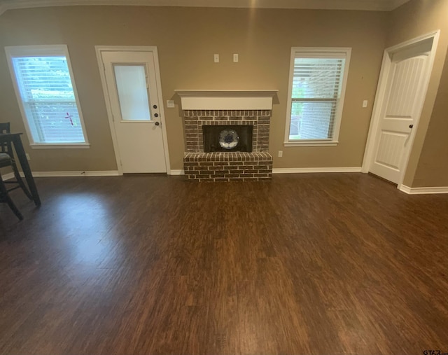 5848 Grace Ave, Tyler, TX 75707 - unfurnished living room featuring dark wood-type flooring, baseboards, and plenty of natural light