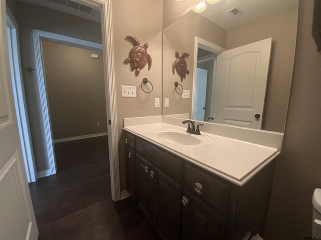5848 Grace Ave, Tyler, TX 75707 - half bath featuring wood finished floors, vanity, and baseboards