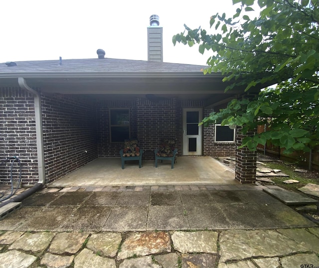 5848 Grace Ave, Tyler, TX 75707 - rear view of house with brick siding, a patio, and a chimney