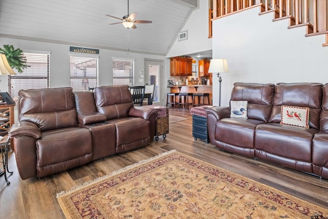 living room featuring high vaulted ceiling, a ceiling fan, light wood-style floors, and visible vents