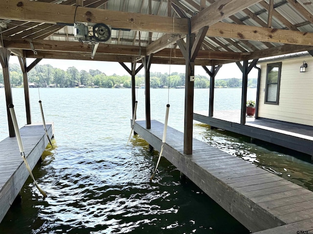 dock area featuring boat lift and a water view