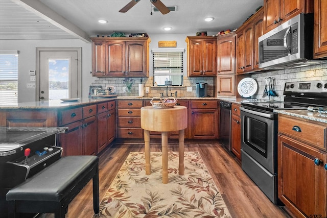 kitchen featuring a wealth of natural light, appliances with stainless steel finishes, and dark wood-style floors