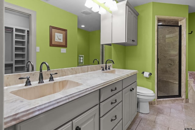bathroom with double vanity, a shower stall, toilet, and a sink