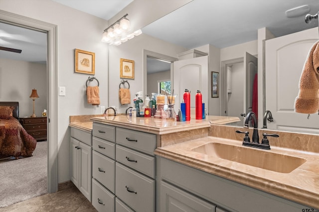 ensuite bathroom with double vanity, connected bathroom, tile patterned floors, and a sink