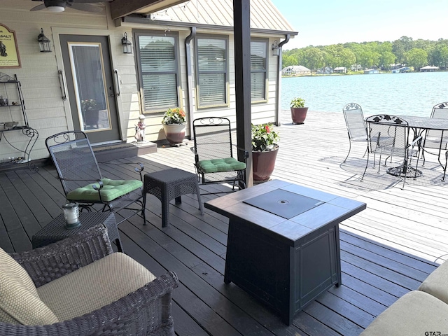 deck featuring outdoor dining area and a water view
