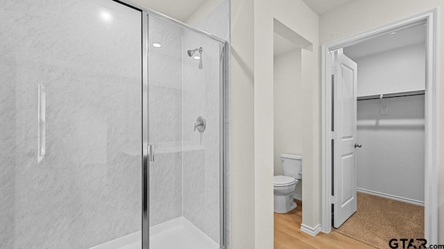 490 Burnett Trl, Canton, TX 75103 - full bathroom featuring a shower stall, a spacious closet, and wood finished floors