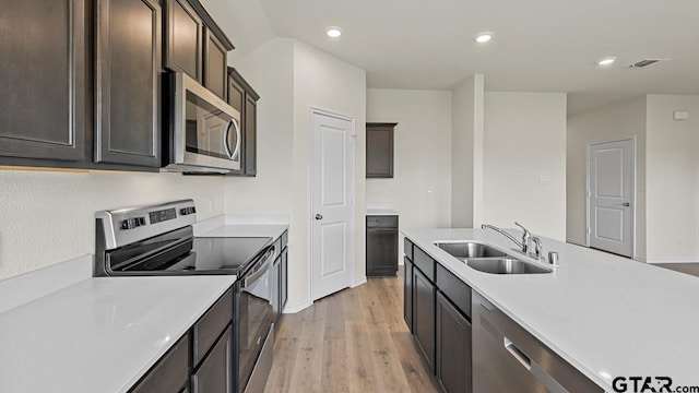 490 Burnett Trl, Canton, TX 75103 - kitchen with appliances with stainless steel finishes, light wood-type flooring, light countertops, dark brown cabinets, and recessed lighting