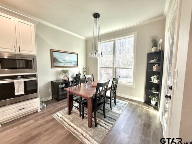 dining space featuring ornamental molding and hardwood / wood-style flooring