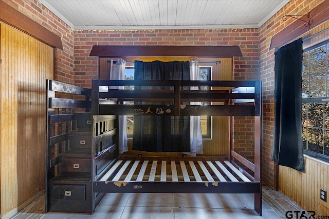 interior space featuring brick wall, wood walls, and crown molding