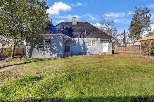 rear view of house featuring a lawn