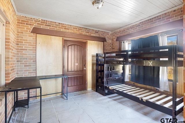 foyer featuring brick wall