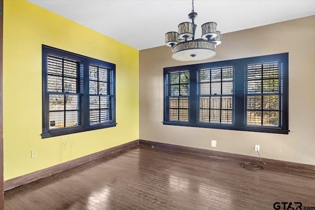 unfurnished dining area with an inviting chandelier and hardwood / wood-style floors