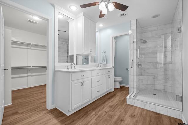 3316 S Cameron Ave, Tyler, TX 75701 - bathroom featuring a ceiling fan, a shower stall, double vanity, wood finished floors, and recessed lighting