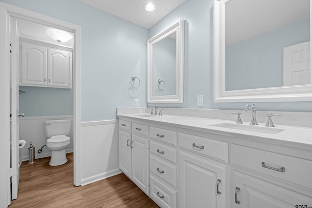 3316 S Cameron Ave, Tyler, TX 75701 - bathroom with double vanity, a wainscoted wall, and wood finished floors