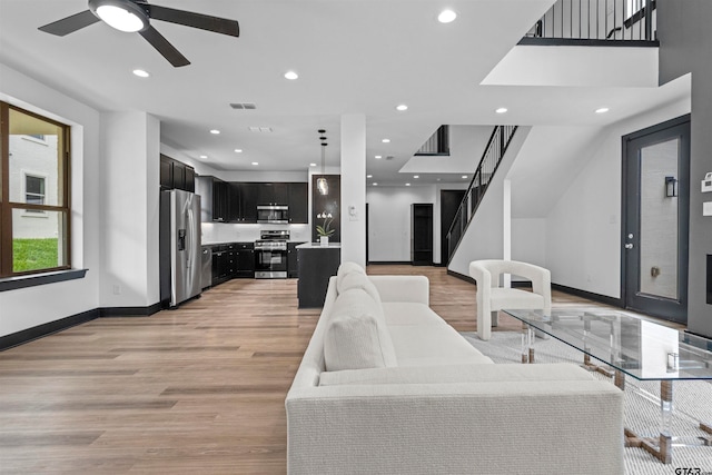 living room featuring ceiling fan and light hardwood / wood-style flooring