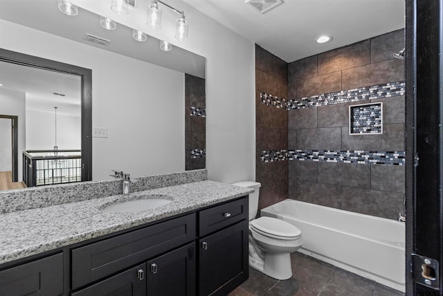 full bathroom featuring toilet, vanity, tiled shower / bath, and tile patterned flooring