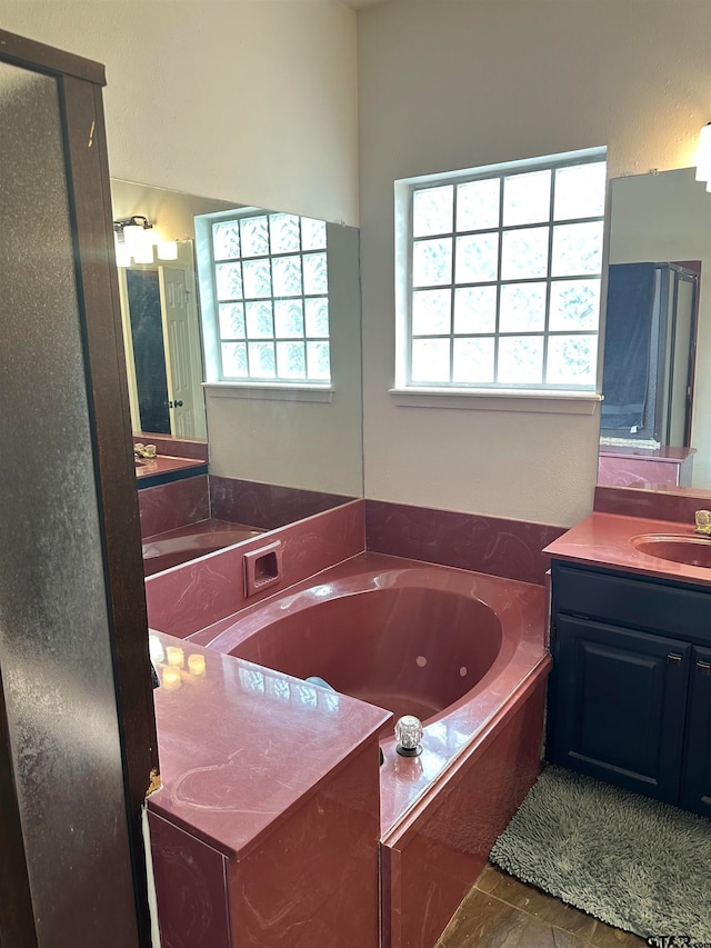 bathroom featuring vanity, a tub, tile patterned flooring, and plenty of natural light