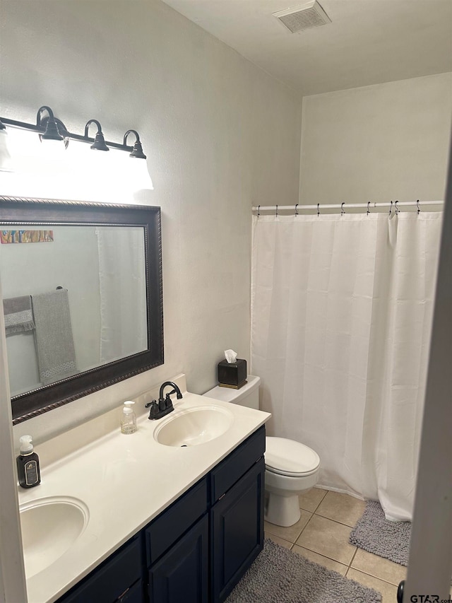 bathroom with vanity, tile patterned flooring, and toilet