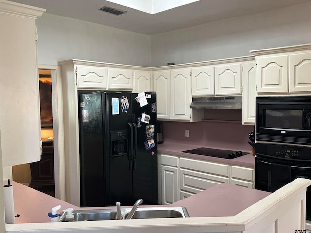 kitchen with black appliances and white cabinetry