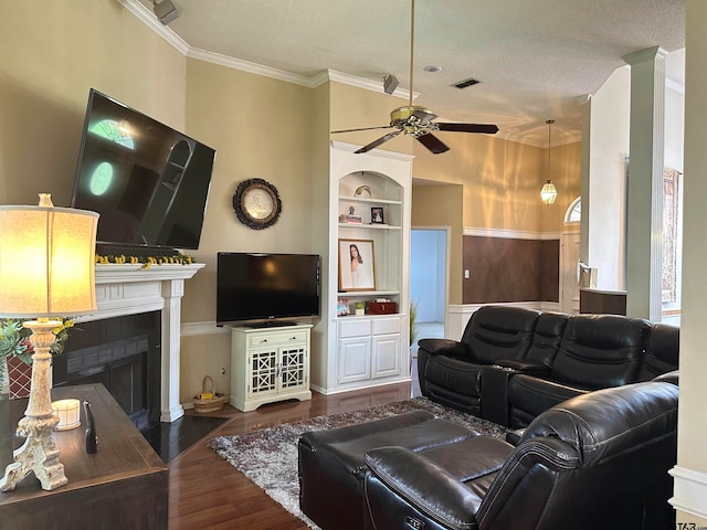 living room with built in shelves, crown molding, a textured ceiling, dark hardwood / wood-style floors, and ceiling fan