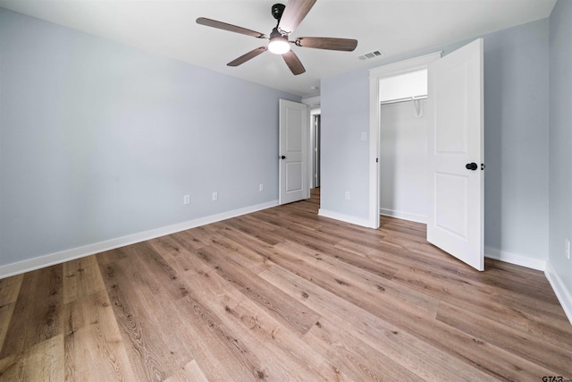 unfurnished bedroom with light hardwood / wood-style flooring, ceiling fan, and a closet