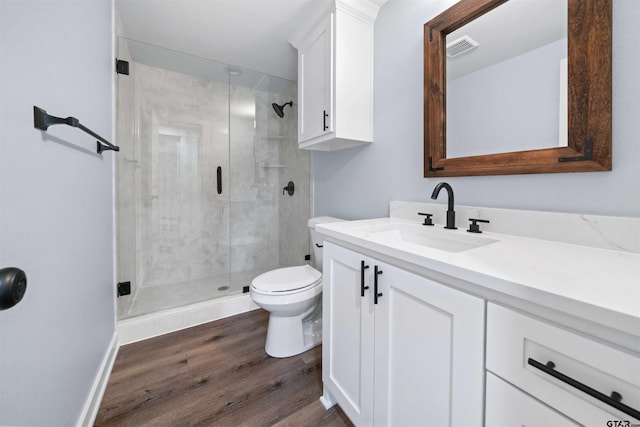 bathroom featuring walk in shower, vanity, hardwood / wood-style flooring, and toilet