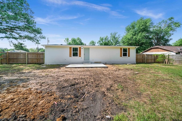 rear view of property featuring a patio area and a lawn