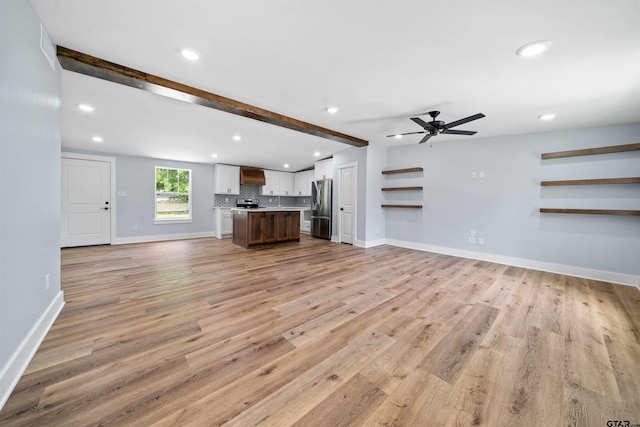 unfurnished living room with ceiling fan, light hardwood / wood-style floors, and beamed ceiling